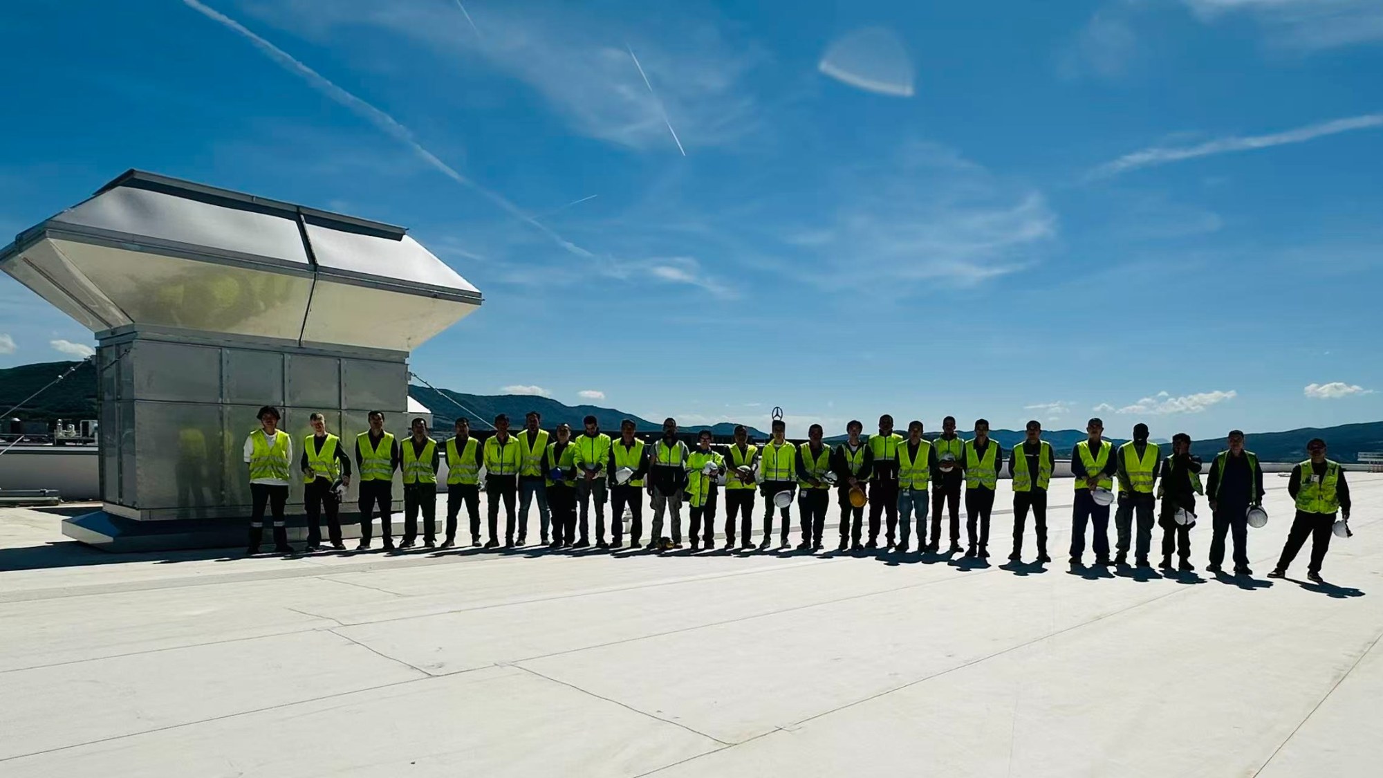 Montageteam auf dem Dach der Produktionsanlage
